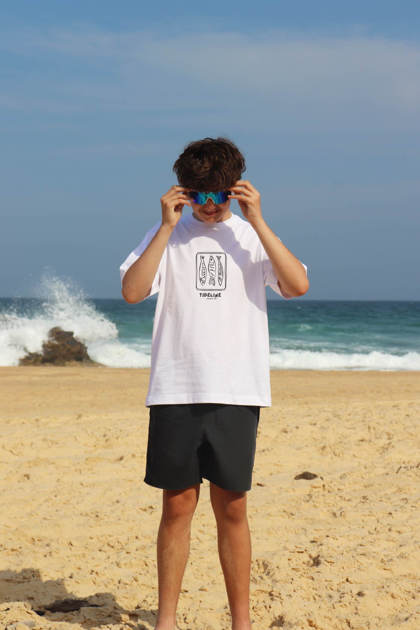 Model wearing white Heavyweight Aussie Coastal Graphic Tee by the water